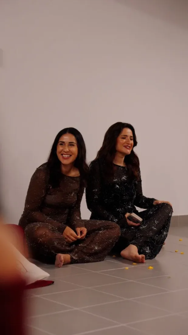 Rita e Marlene sentadas no chão, a rir